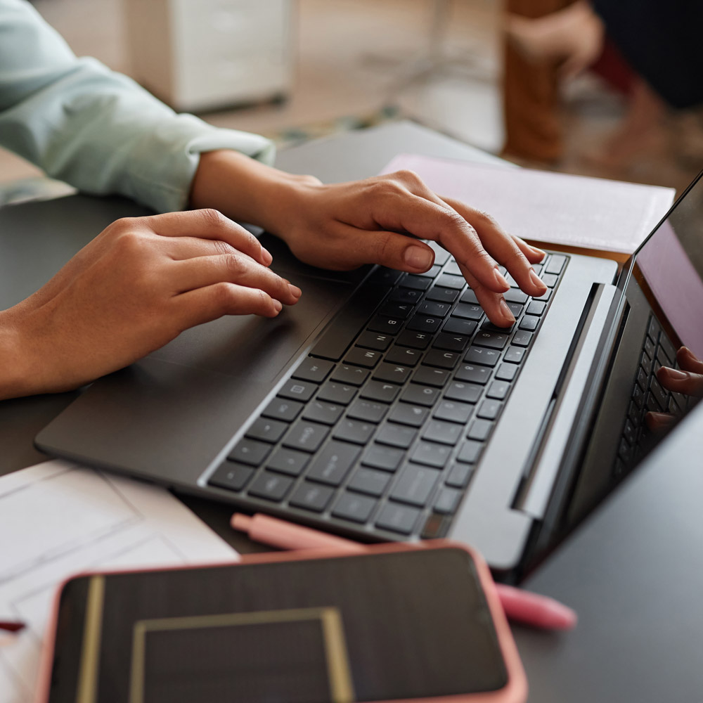 Person typing on laptop keyboard